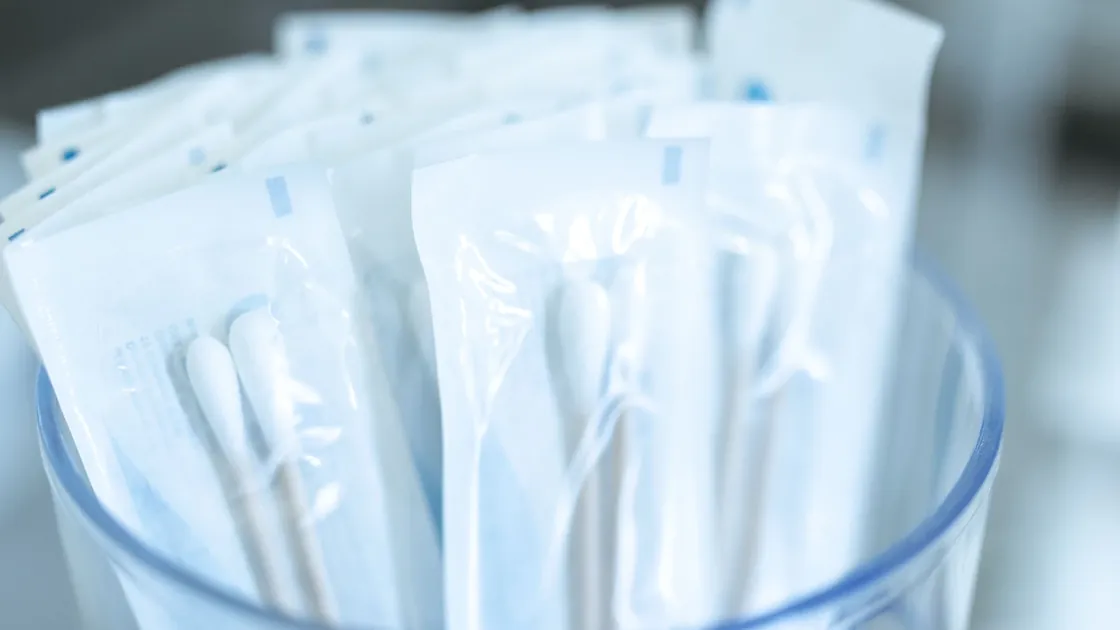 Individually packaged cotton swabs organized in a clear container.