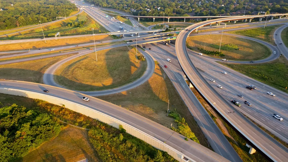 Aerial view of multi-level highway interchange and looping ramps carrying traffic.